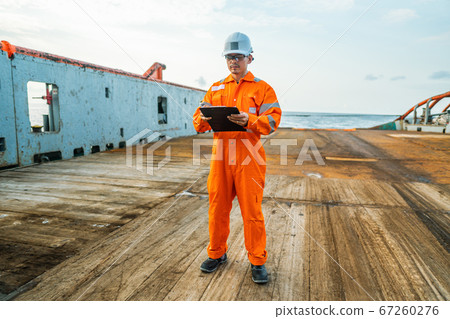 Filipino deck Officer on deck of offshore vessel or ship fills checklist. Paperwork at sea Filipino deck Officer on deck of offshore vessel or ship fills checklist. Paperwork at sea 67260276