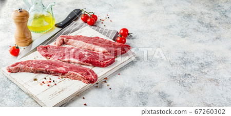 Raw steak with spices on wooden cutting board Raw steak with spices on wooden cutting board 67260302