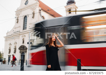 A young beautiful stylish girl in a black summer dress with heels walks in the city.Girl model in the Czech Republic. BRNO A young beautiful stylish girl in a black summer dress with heels walks in the city.Girl model in the Czech Republic. BRNO 67265975