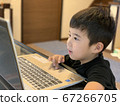 A boy in the first grade of elementary school who enjoys studying on a computer 67266705
