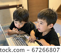 Two boy brothers studying happily on a computer 67266807