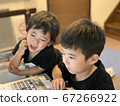 Two boy brothers studying happily on a computer 67266922
