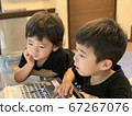 Two boy brothers studying happily on a computer 67267076