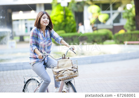 Female college student riding a bicycle Female college student riding a bicycle 67268001