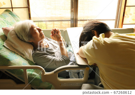 An elderly mother lying in a care bed and a daughter who is tired of care and falls asleep An elderly mother lying in a care bed and a daughter who is tired of care and falls asleep 67268612