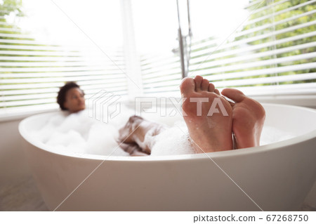 Woman relaxing in a bathtub Woman relaxing in a bathtub 67268750
