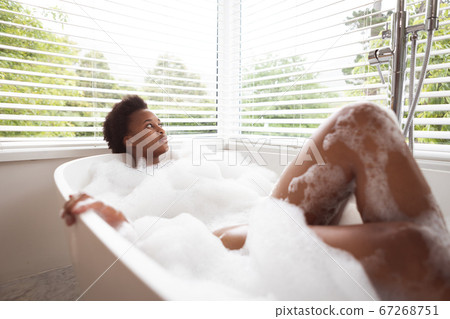 Woman relaxing in a bathtub Woman relaxing in a bathtub 67268751