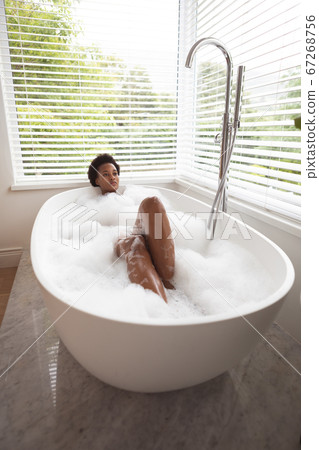 Woman relaxing in a bathtub Woman relaxing in a bathtub 67268756