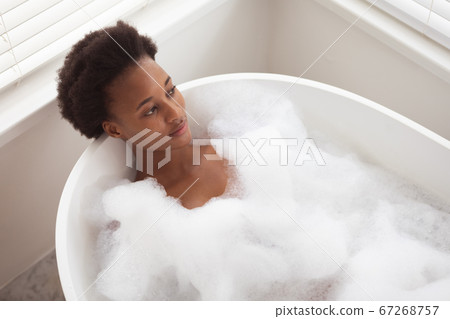 Woman relaxing in a bathtub Woman relaxing in a bathtub 67268757