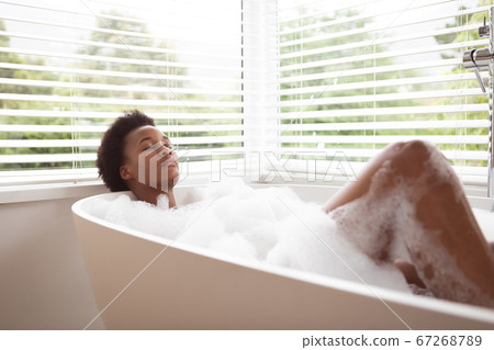 Woman relaxing in a bathtub Woman relaxing in a bathtub 67268789