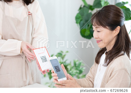 使用QR碼定居的中年女性 使用QR碼定居的中年女性 67269626