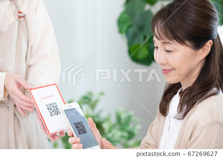 使用QR碼定居的中年女性 使用QR碼定居的中年女性 67269627