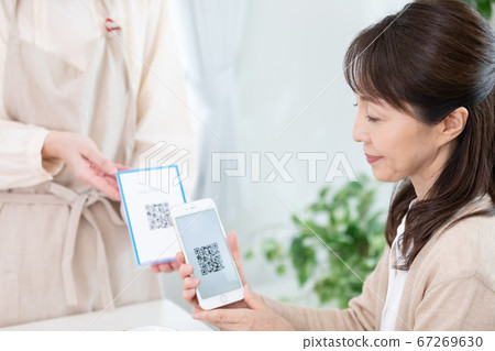 使用QR碼定居的中年女性 使用QR碼定居的中年女性 67269630