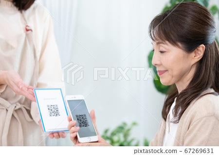 使用QR碼定居的中年女性 使用QR碼定居的中年女性 67269631
