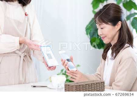 使用QR碼定居的中年女性 使用QR碼定居的中年女性 67269634