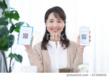 使用QR碼定居的中年女性 使用QR碼定居的中年女性 67269646