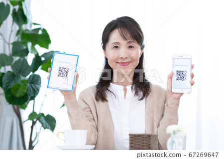 使用QR碼定居的中年女性 使用QR碼定居的中年女性 67269647
