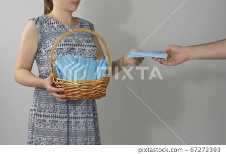 girl holds a basket with medical masks. girl holds a basket with medical masks. 67272393