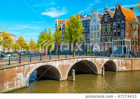 Waterfront with traditional dutch houses and old bridge, Amsterdam, Netherlands Waterfront with traditional dutch houses and old bridge, Amsterdam, Netherlands 67274433