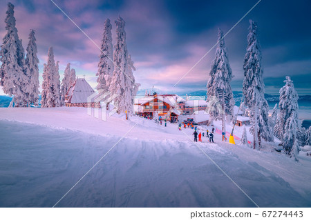Famous ski resort with skiers at sunset, Poiana Brasov, Romania Famous ski resort with skiers at sunset, Poiana Brasov, Romania 67274443