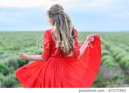 Happy woman in red dress dancing and jumping in lavender field 67275993