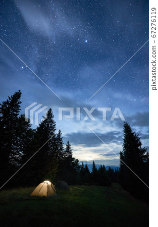 Magical starry night at a campsite in the mountains during summer time Magical starry night at a campsite in the mountains during summer time 67276119