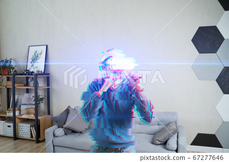 Man with virtual reality headset is playing game and fighting. Image with glitch effect. 67277646