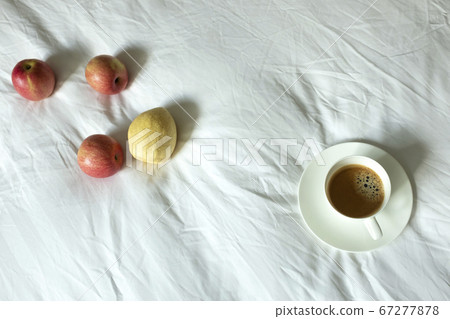 Fruit and coffee on the bed sheet Fruit and coffee on the bed sheet 67277878