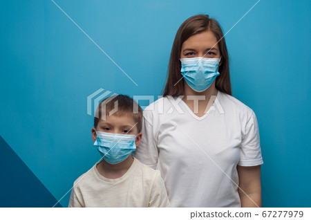 Caucasian mother and son wearing protective medical mask. 67277979