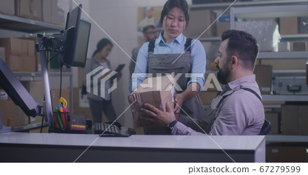 Workers checking damaged package 67279599