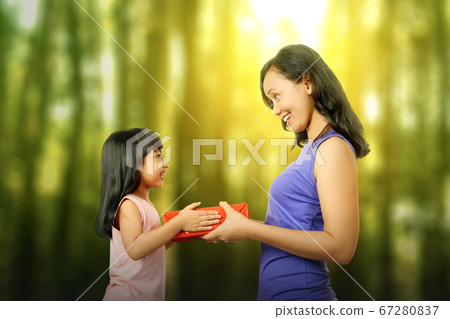 Asian little girl giving her mother a gift box 67280837