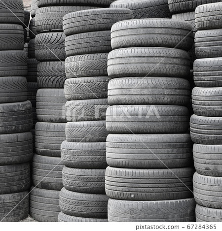 Old used tires stacked with high piles in 67284365