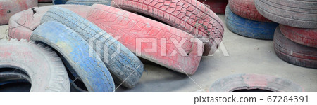 A picture of many old used tires left on a waste A picture of many old used tires left on a waste 67284391