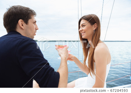 Happy couple drinking vodka cocktails at boat party outdoor, cheerful and happy Happy couple drinking vodka cocktails at boat party outdoor, cheerful and happy 67284593