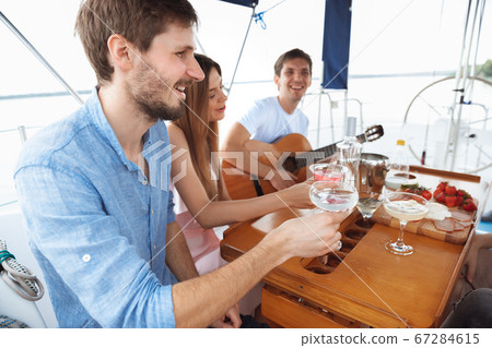 Group of happy friends drinking vodka cocktails at boat party outdoor, cheerful and happy Group of happy friends drinking vodka cocktails at boat party outdoor, cheerful and happy 67284615