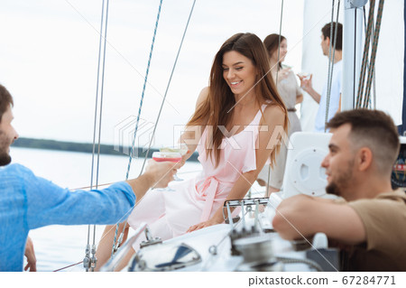 Happy smiling woman drinking vodka cocktails at boat party outdoor, cheerful and happy Happy smiling woman drinking vodka cocktails at boat party outdoor, cheerful and happy 67284771