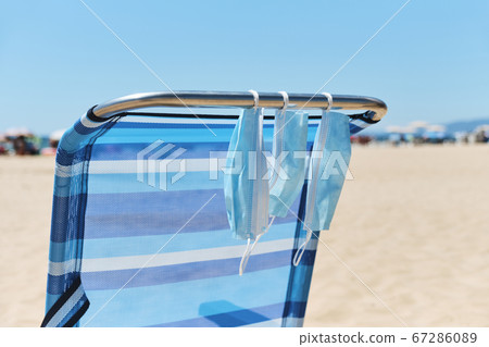 face masks hanging on a deck chair on the beach face masks hanging on a deck chair on the beach 67286089