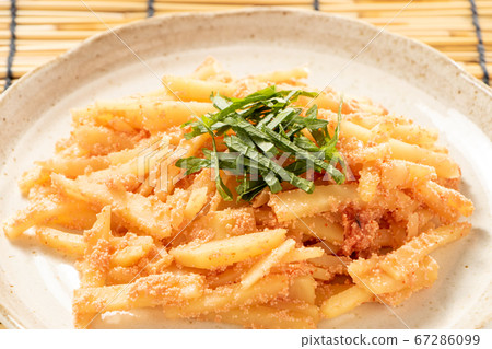 Stir-fried potatoes and mentaiko mentaiko (with large leaves). Background, blinds. Stir-fried potatoes and mentaiko mentaiko (with large leaves). Background, blinds. 67286099