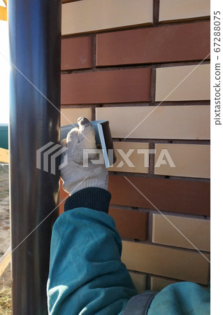 The worker attaches to the wall of the house drainage. The worker attaches to the wall of the house drainage. 67288075