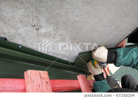 Workers line the chimney with green metal Workers line the chimney with green metal 67288204