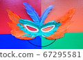 Carnival mask made of feathers on a multicolored 67295581