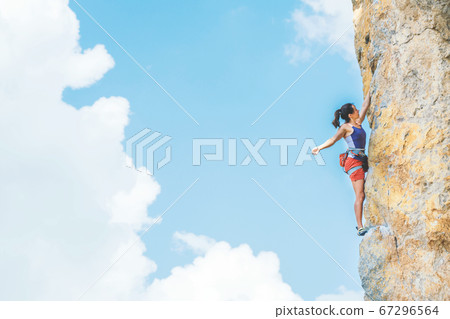Woman climbs a rock. Woman climbs a rock. 67296564