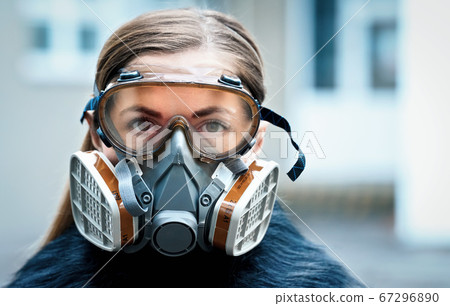 Young woman wearing full face respirator 67296890