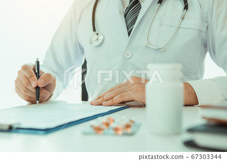 Doctor hand holding pen writing patient history Doctor hand holding pen writing patient history 67303344