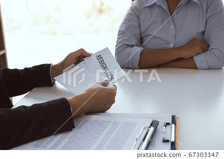 Male employee handed out a resignation envelope to Male employee handed out a resignation envelope to 67303347