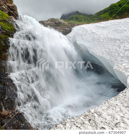 Beautiful view of cascade waterfall falling into glacier in rocky mountain 67304907