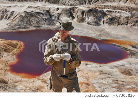 geologist examines a sample of mineral in the geologist examines a sample of mineral in the 67305820