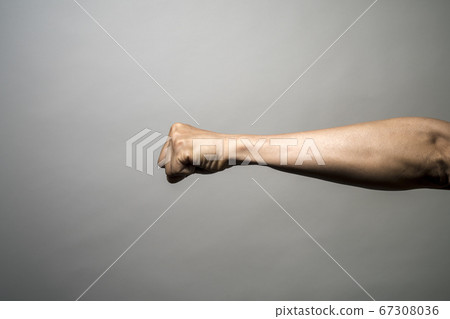 Clenched fist in front of white background Clenched fist in front of white background 67308036