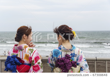 一個穿著浴衣的女人在海邊漫步 67308648