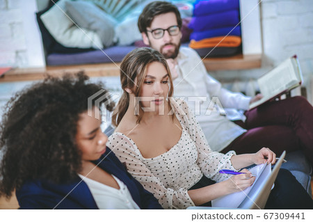 Girl rewriting information from laptop screen, boyfriend and girlfriend around 67309441